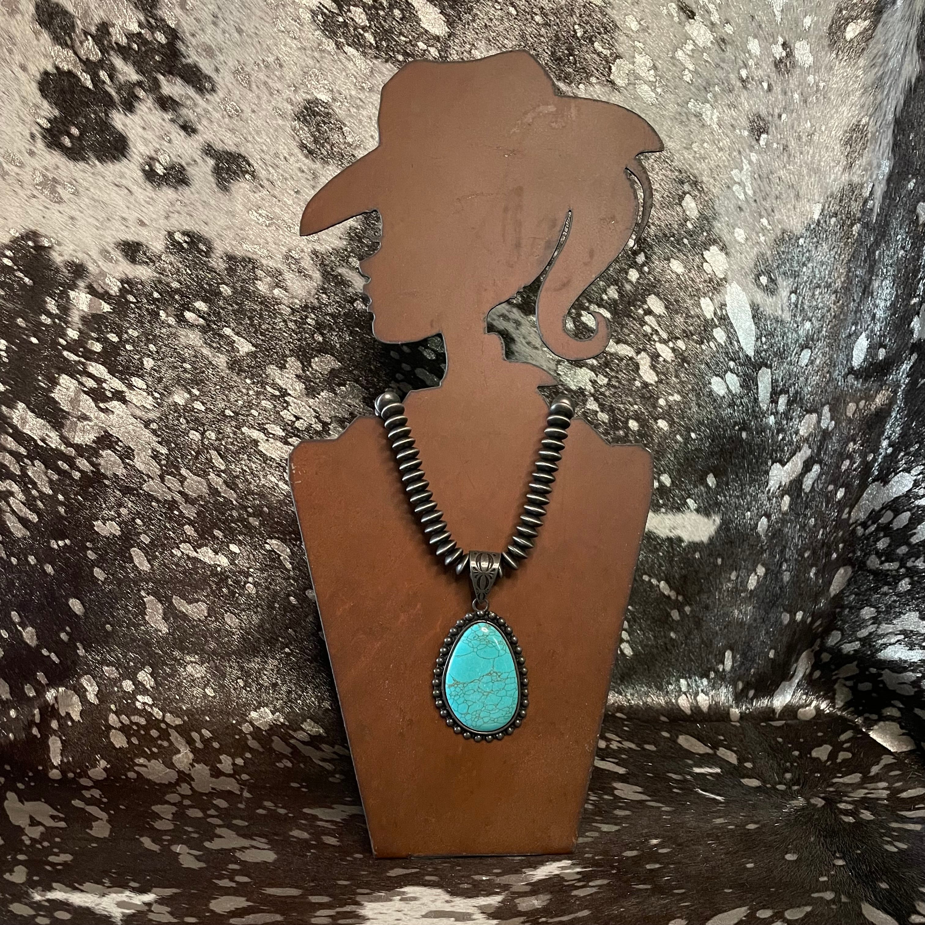 Necklace with a turquoise pendant on a brown silhouette against a textured background